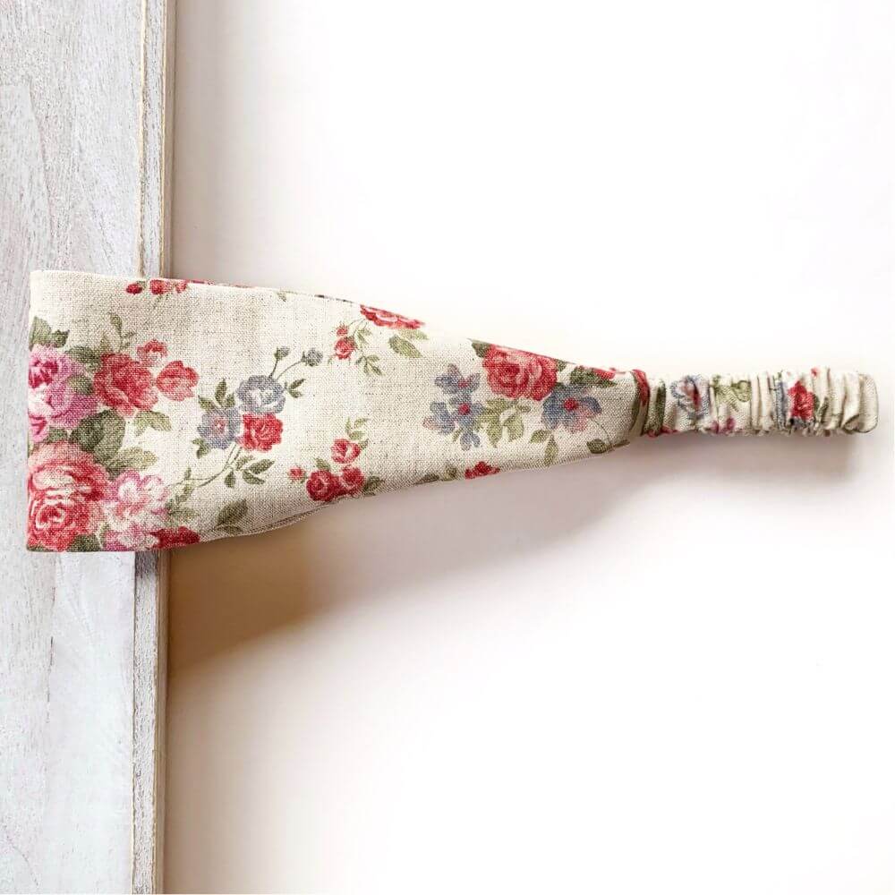 Natural Cotton Linen rose floral patterned headband on a light wooden surface