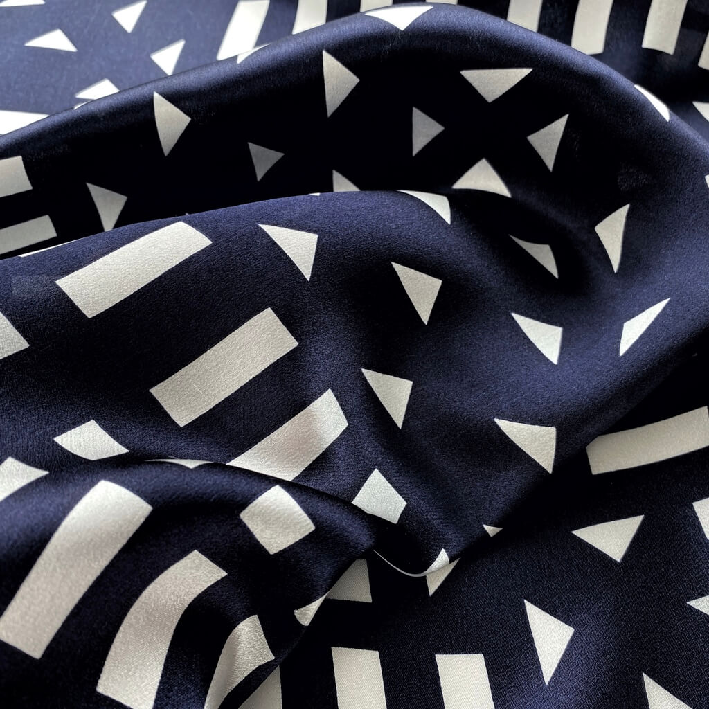 Close-up of navy blue and white geometric mulberry silk square scarf