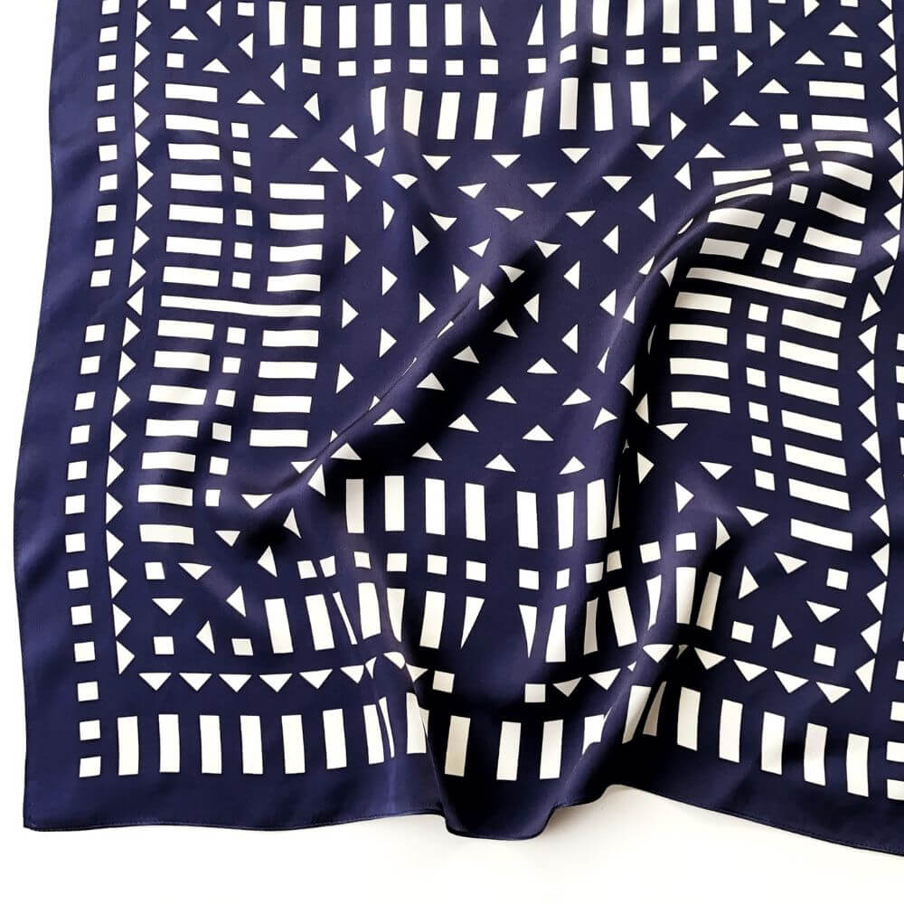 Navy blue and white geometric mulberry silk square scarf laid flat on a white background
