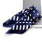 Navy blue silk scarf with white geometric pattern on a white surface