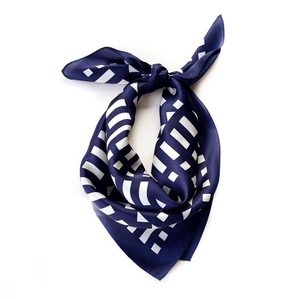 Navy blue silk scarf with white geometric pattern on a white background