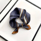 Navy blue and brown geometric patterned mulberry silk square neck scarf on a white background