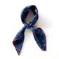 Tied navy blue mulberry silk neck scarf with white abstract patterns and contrasting red border.