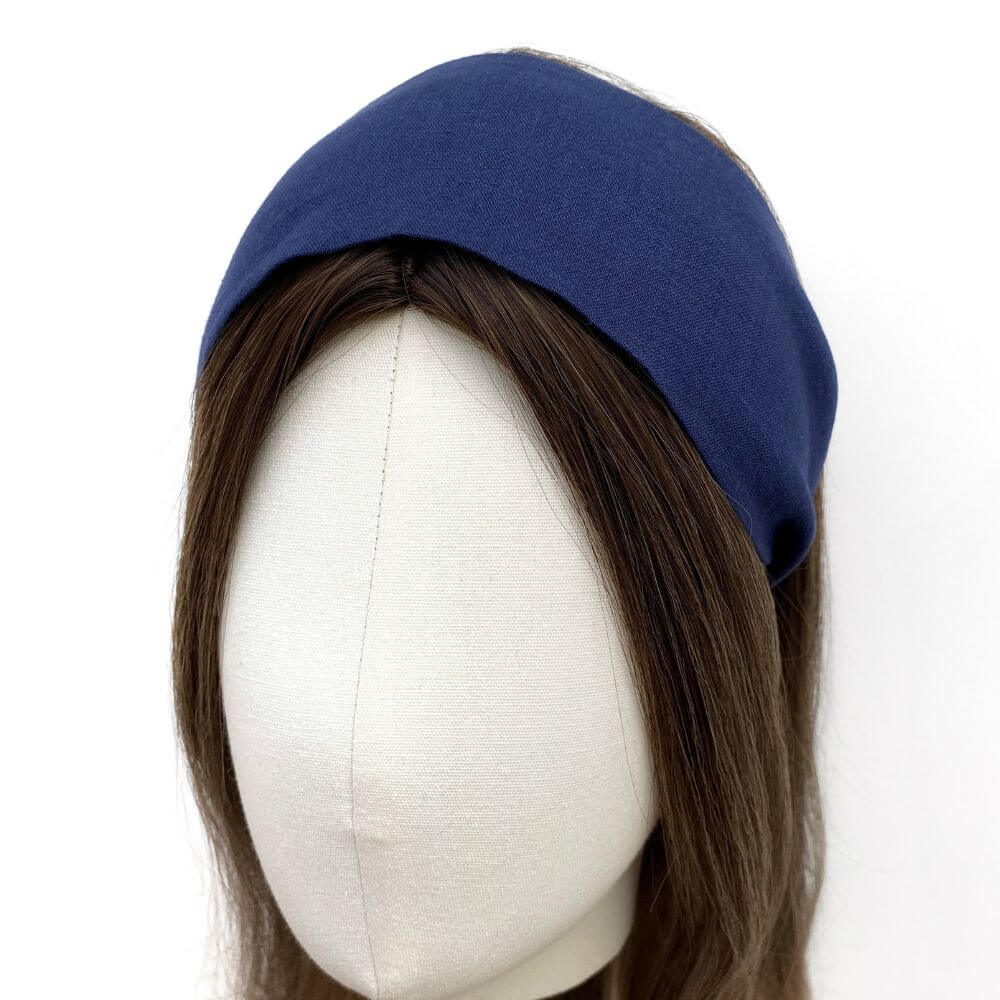 Navy blue headband on a mannequin head with brown hair against a white background