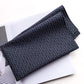 folded navy cotton bandana with white dotted wave pattern on a white surface