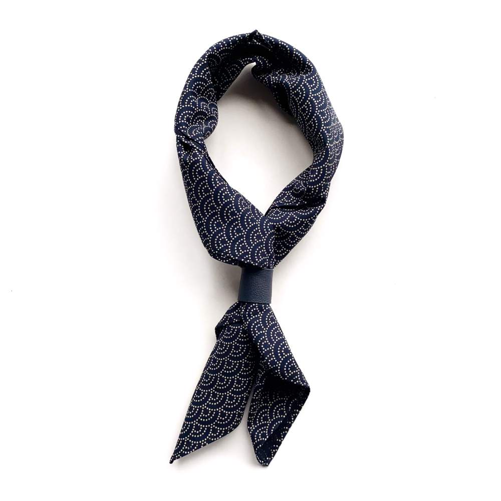 Navy blue wave patterned cotton bandana scarf tied in a knot on a white background