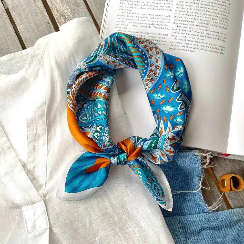 Colorful patterned headscarf on a white shirt with an open book in the background