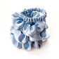 Set of light blue pure mulberry silk satin scrunchies and hair ties on a white background