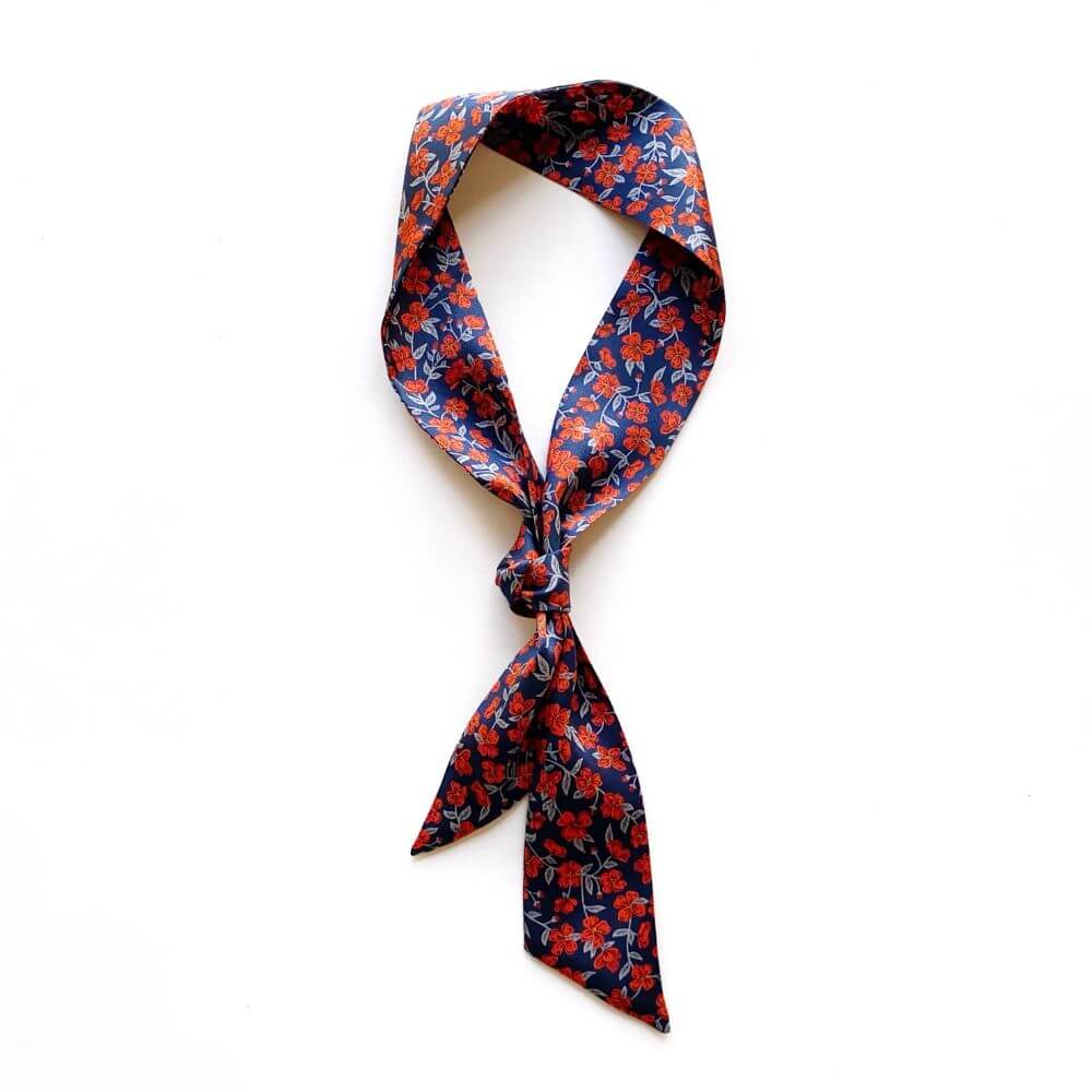 Floral patterned  liberty silk skinny scarf tied on a white background