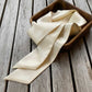 ivory cream coloured mulberry silk satin skinny scarf in the box, placed on the table 
