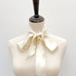 An ivory cream mulberry silk satin skinny neck scarf tied in a large bow knot and draped down the front of a mannequin 