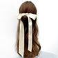 A long ivory cream skinny silk satin scarf styled in a half-up bun on a mannequin head