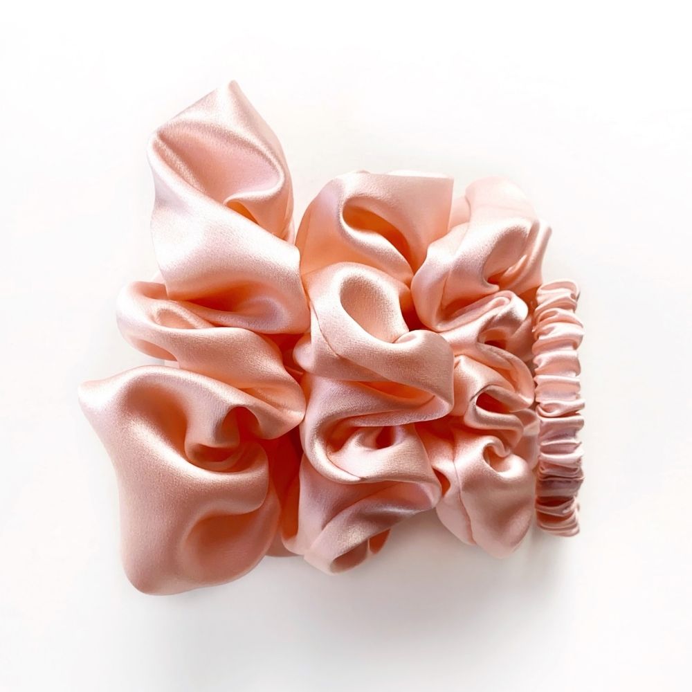 Pink  mulberry silk satin scrunchies and silk hair tie on a white background