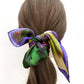Multicolored mulberry silk hair scarf tied in a ponytail on a white background