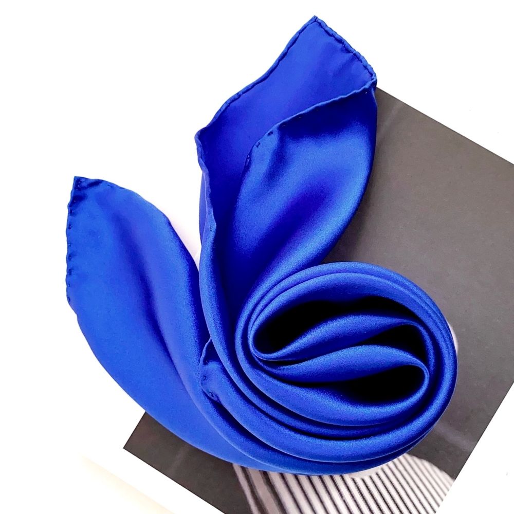 Close-up of royal blue silk scarf rolled into a spiral