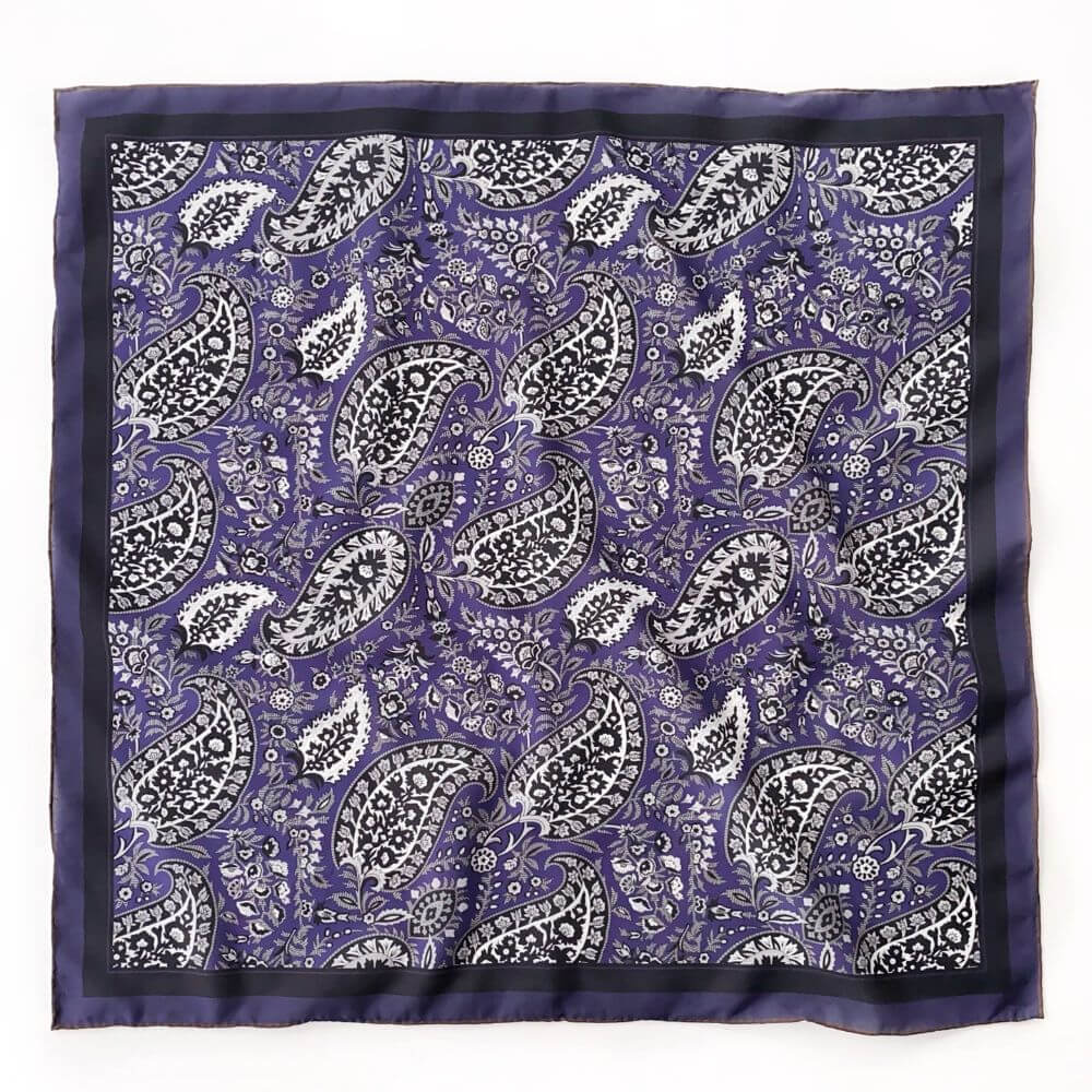 Flat lay of the purple paisley silk cotton blend square scarf, displaying the full detailed print and contrast border.