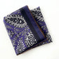 Folded purple paisley silk cotton blend scarf showing the border and intricate floral paisley pattern.
