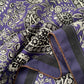 Close-up of the purple paisley silk cotton blend scarf, highlighting the hand-rolled hem and smooth fabric texture.