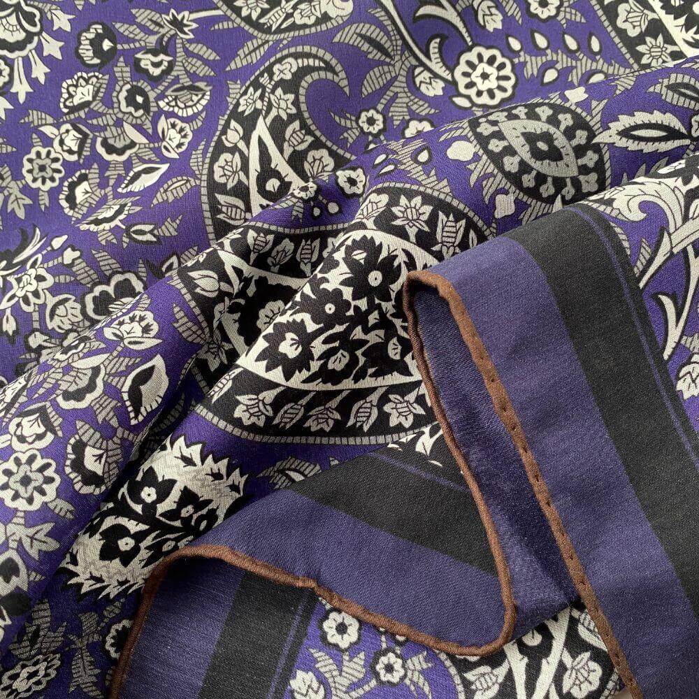 Close-up of the purple paisley silk cotton blend scarf, highlighting the hand-rolled hem and smooth fabric texture.
