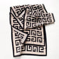 Blush pink and black geometric Mulberry silk scarf laid flat with soft folds, showing the maze-style pattern and border.