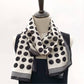 Black and white polka dot silk Crepe de Chine scarf draped around a mannequin, styled loosely around the neck.