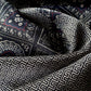 Black geometric and floral Mulberry silk scarf close-up showing smooth satin texture