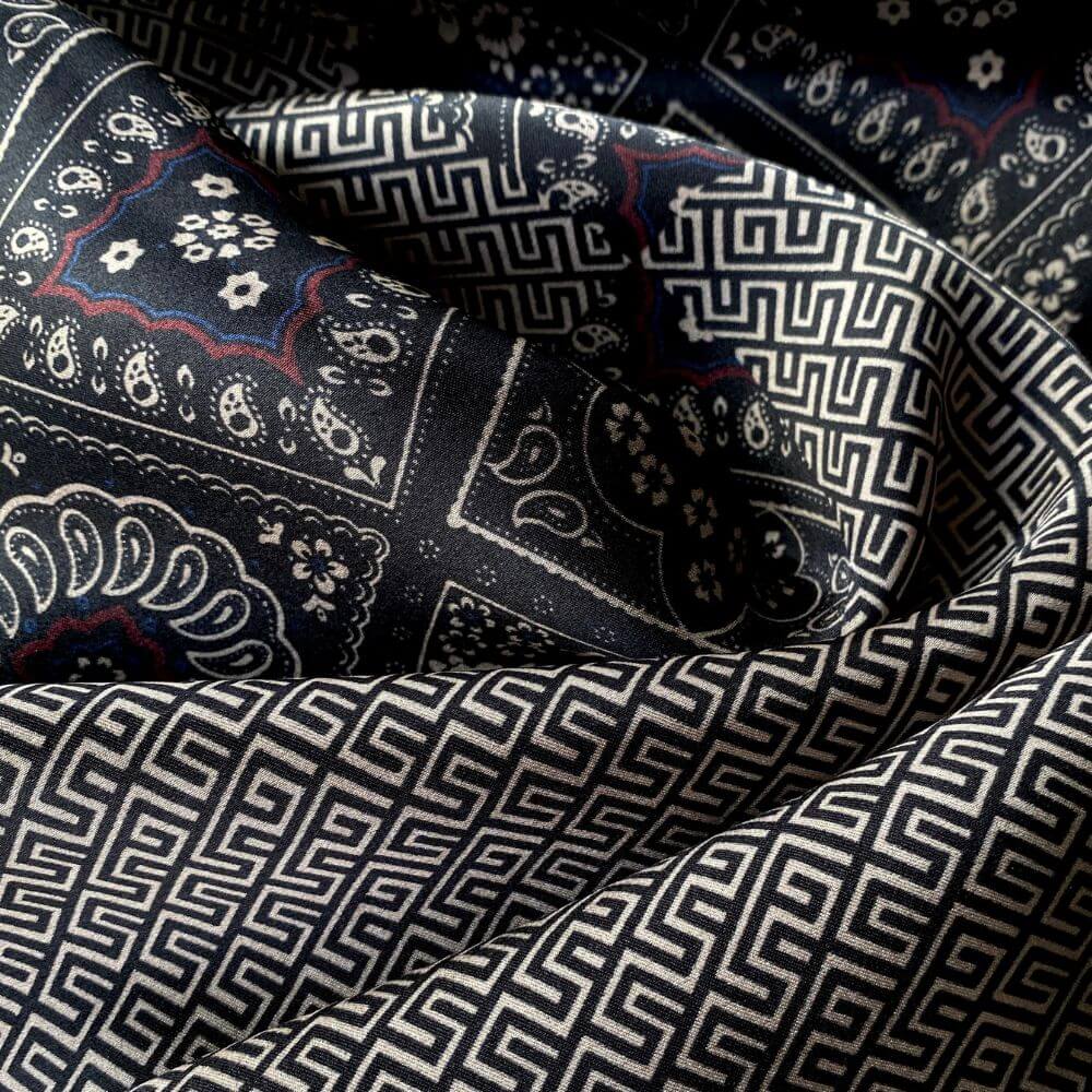 Black geometric and floral Mulberry silk scarf close-up showing smooth satin texture