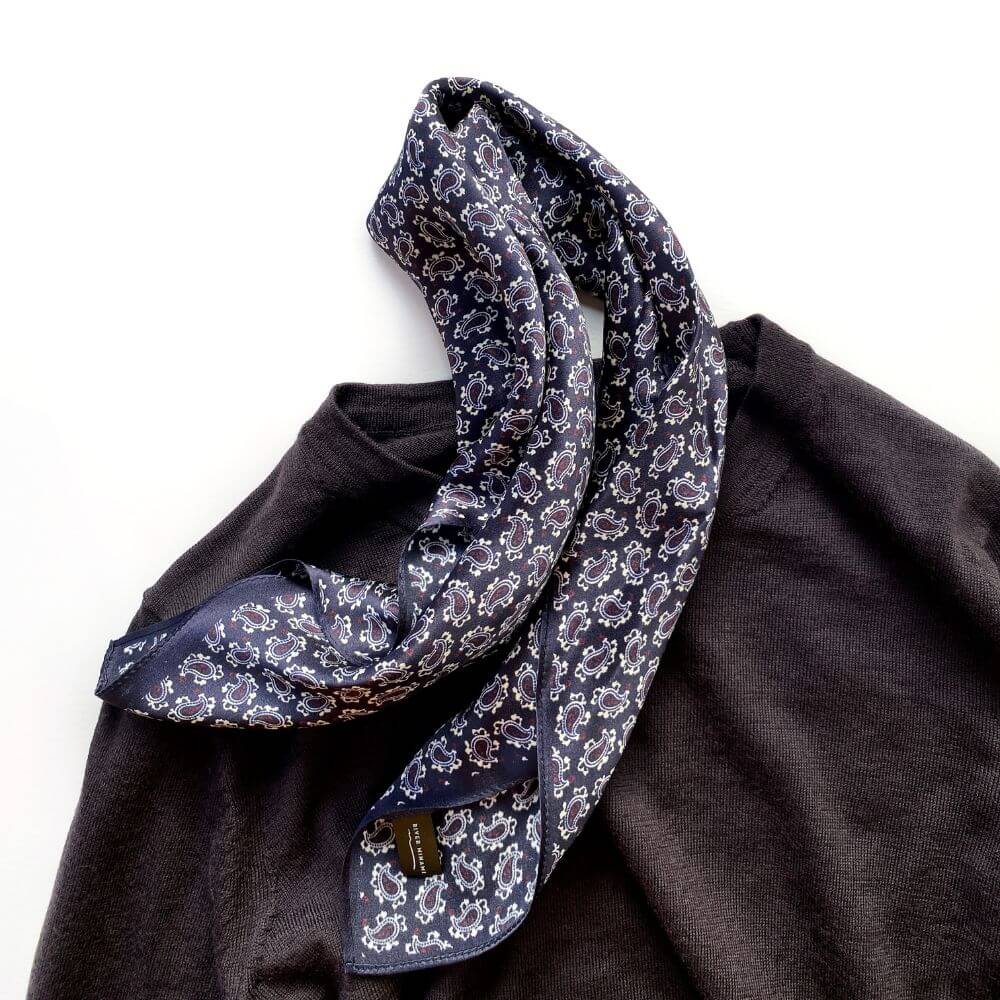 Dark purple mini-paisley Mulberry silk scarf styled on a brown sweater
