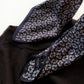 Detailed close-up of mini paisley motifs on dark purple Mulberry silk on a sweater.