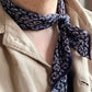 Man wearing dark purple paisley silk scarf as a neckerchief