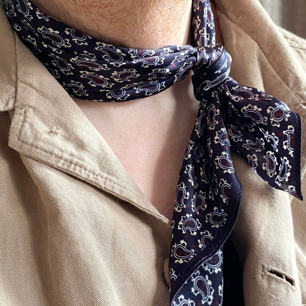 Man wearing dark purple paisley silk scarf as a neckerchief