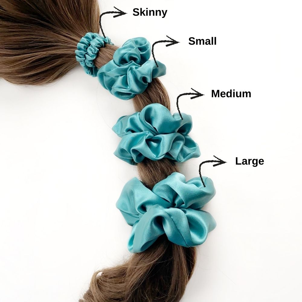 Set of teal blue pure mulberry silk satin scrunchies and hair ties of different sizes on a ponytail with size labels.