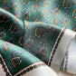 Close-up of a teal green equestrian stirrup patterned mulberry silk square scarf with gold and silver accents