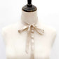 Mannequin wearing a champagne Beige mulberry silk ribbon scarf into a bow tie on a white background