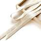Close-up of ivory cream mulberry silk ribbons in a wooden box on a light background