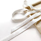 White skinny mulberry silk ribbon on a wooden surface with a white background