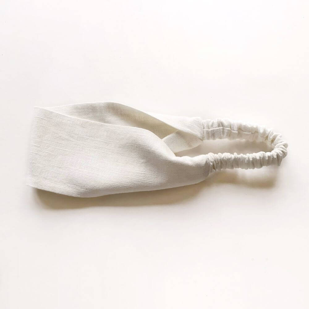 White headband on a warm white background