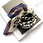 wrapped black leopard print ivory mulberry silk square scarf with blue and brown border on top of a book.