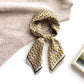 yellow brown geometric patterned mulberry silk bandana scarf on a textured surface