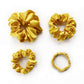 Four yellow silk satin scrunchies on a white background